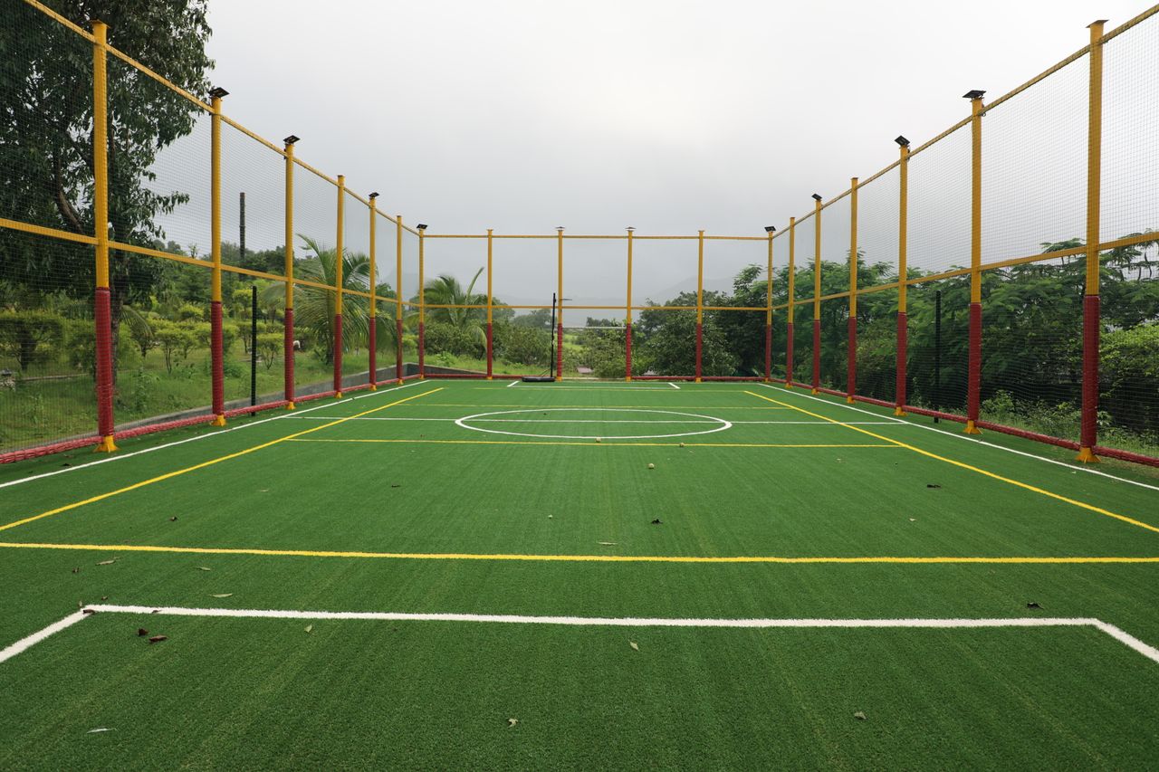 Cancha de fútbol 5 de césped sintético rodeada por una malla.